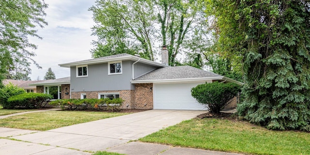 split level home featuring concrete driveway, a chimney, an attached garage, a front lawn, and brick siding