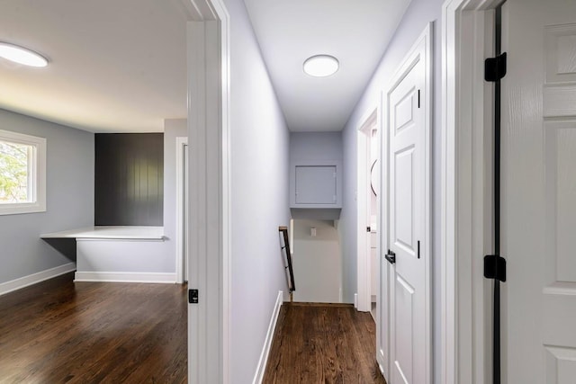 hallway featuring dark wood-style floors and baseboards