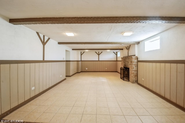 below grade area with wainscoting, a fireplace, and wood walls