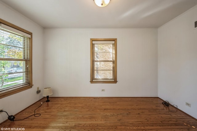 unfurnished room with ornamental molding, wood finished floors, and visible vents