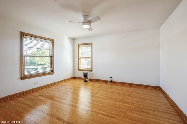 spare room with light wood finished floors, baseboards, and a ceiling fan