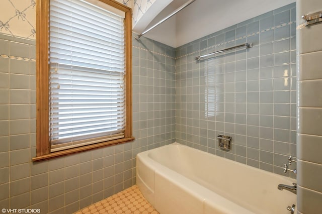 bathroom with bathing tub / shower combination and tile walls