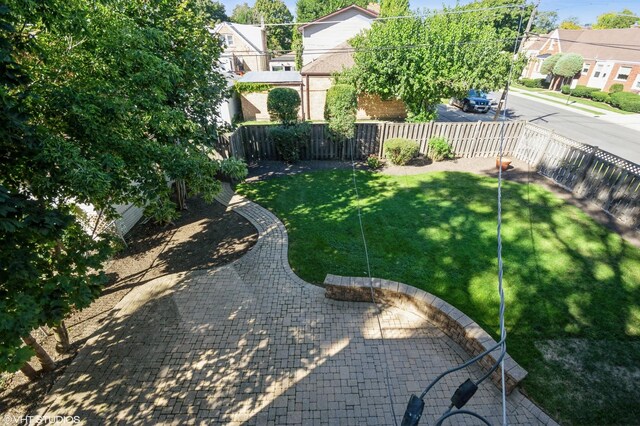 view of yard featuring a residential view, a fenced backyard, and a patio