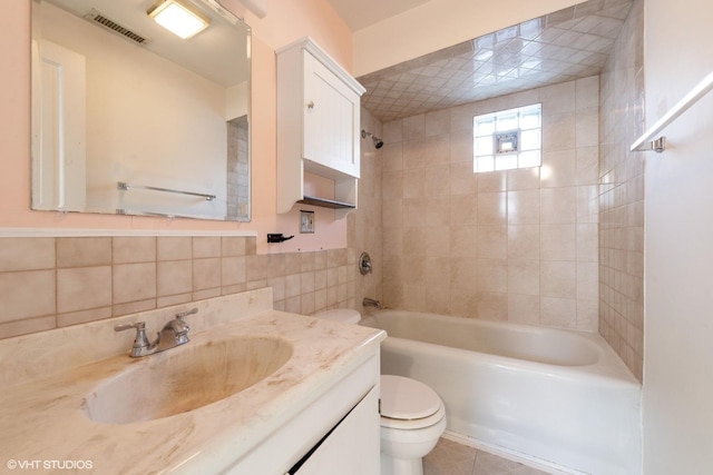 full bath with tile walls, bathtub / shower combination, visible vents, toilet, and vanity