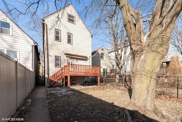 rear view of house with stairway, a fenced backyard, and a wooden deck