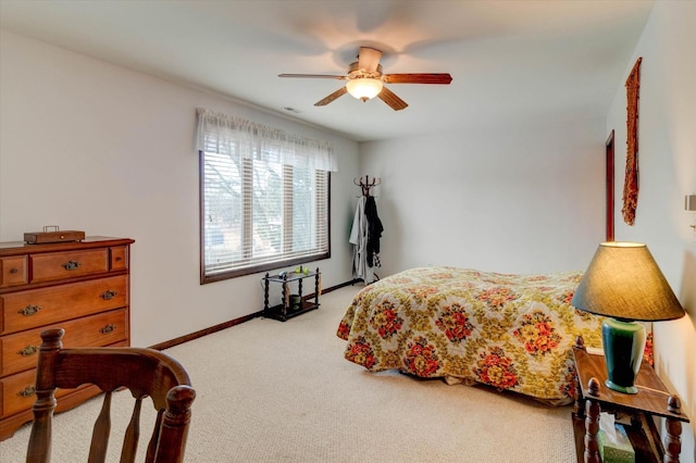 carpeted bedroom with ceiling fan and baseboards