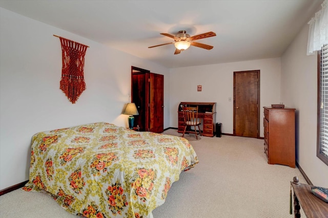 carpeted bedroom with ceiling fan and baseboards