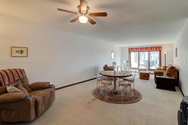 carpeted dining space with ceiling fan and baseboards