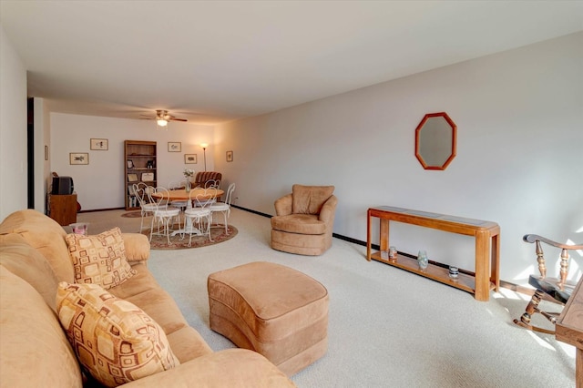 carpeted living area featuring baseboards and a ceiling fan