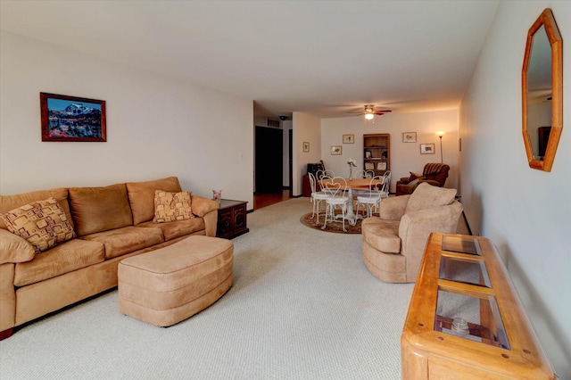 living area with carpet and a ceiling fan