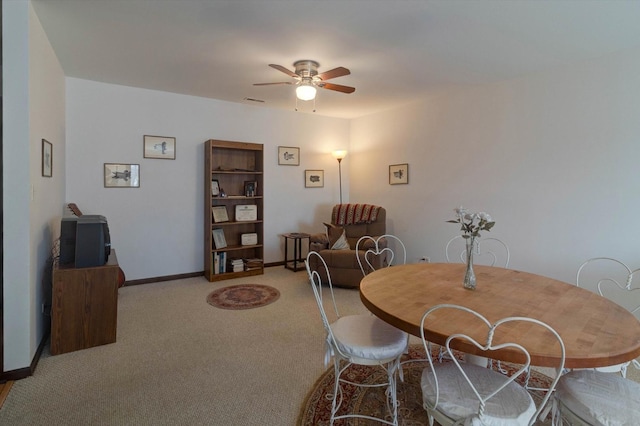 carpeted dining room with baseboards and a ceiling fan