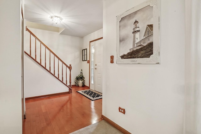 foyer with hardwood / wood-style floors, stairway, and baseboards