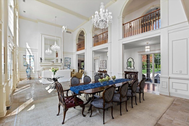 dining room featuring a notable chandelier, stone tile floors, and a decorative wall