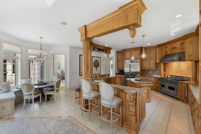 kitchen with premium appliances, light tile patterned floors, backsplash, and exhaust hood