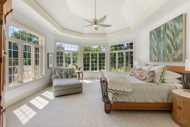 carpeted bedroom with a ceiling fan, baseboards, a raised ceiling, and crown molding