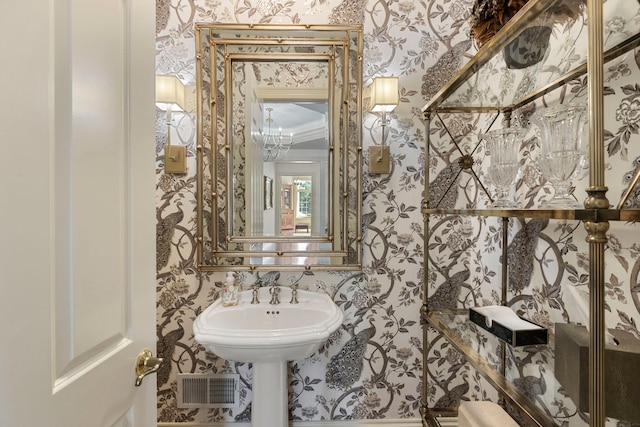 half bath with wallpapered walls and visible vents