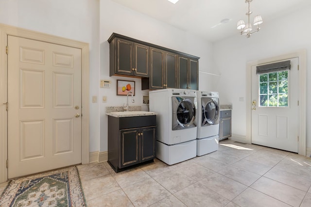 laundry area with cabinet space, independent washer and dryer, a sink, and light tile patterned floors