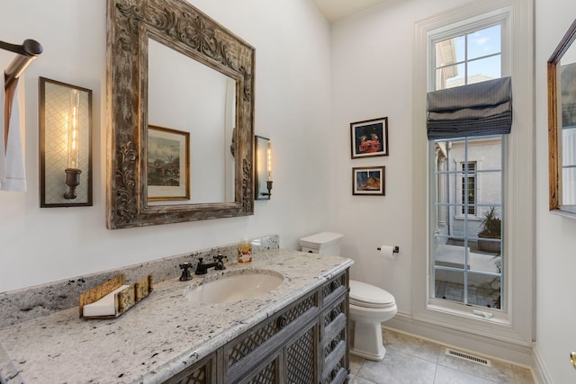 bathroom with toilet, tile patterned flooring, visible vents, and vanity