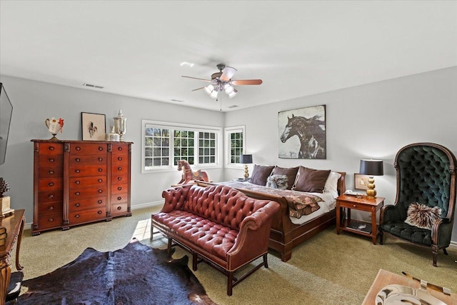 carpeted bedroom featuring a ceiling fan, visible vents, and baseboards