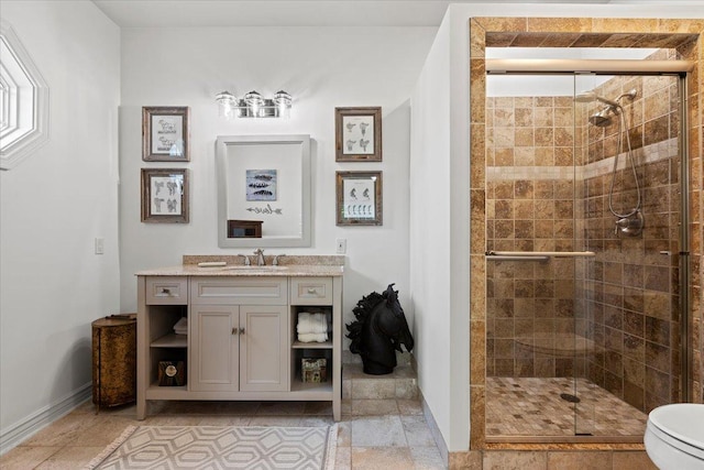 bathroom with a stall shower, vanity, and toilet