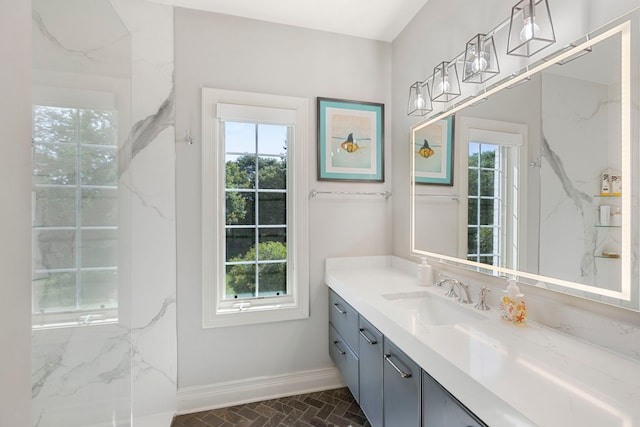 bathroom with a healthy amount of sunlight, brick floor, vanity, and baseboards