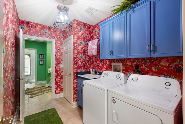 laundry area featuring washer and clothes dryer, visible vents, cabinet space, a sink, and wallpapered walls