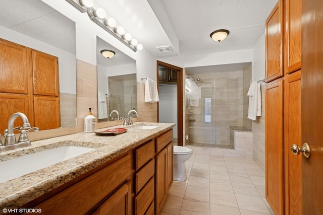 full bathroom featuring visible vents, a sink, a shower stall, and toilet