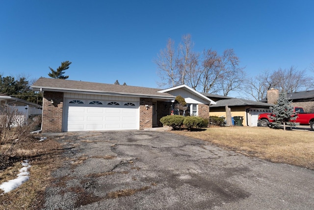 ranch-style home featuring brick siding, driveway, and an attached garage