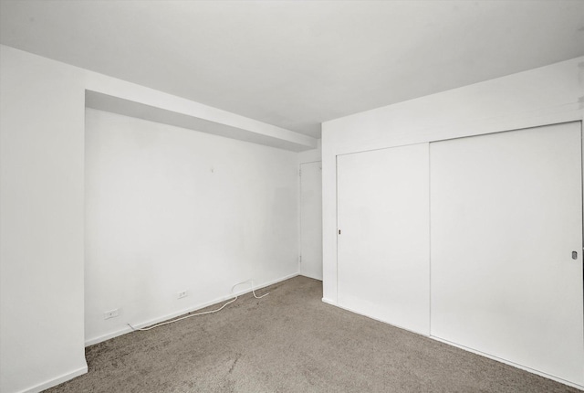 unfurnished bedroom featuring a closet, baseboards, and carpet floors