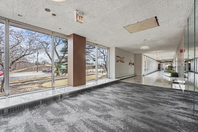 carpeted empty room with a textured ceiling and expansive windows