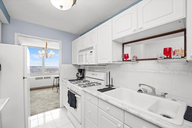 kitchen with radiator heating unit, light countertops, white appliances, white cabinetry, and a sink