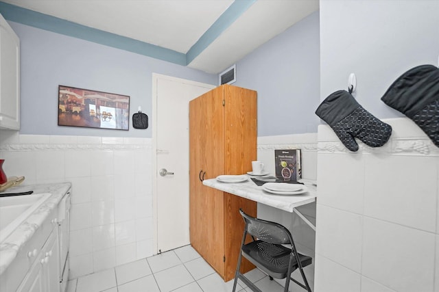 bathroom with vanity, visible vents, tile patterned flooring, wainscoting, and tile walls