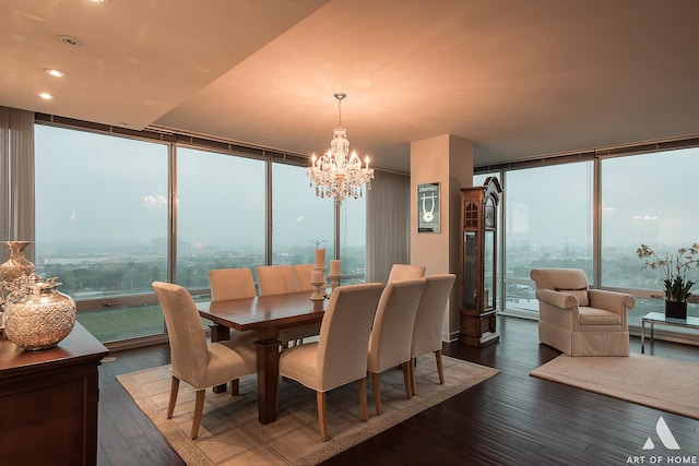 dining space featuring a notable chandelier, a wall of windows, and wood finished floors