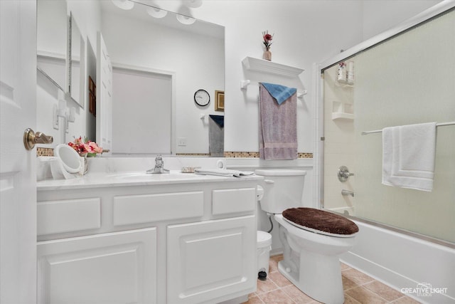 full bathroom with toilet, tile patterned floors, combined bath / shower with glass door, and vanity