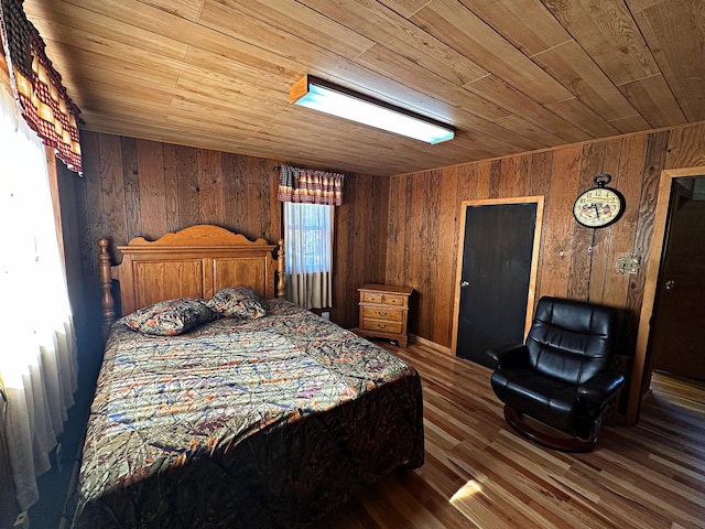 bedroom with wooden walls, wooden ceiling, and wood finished floors