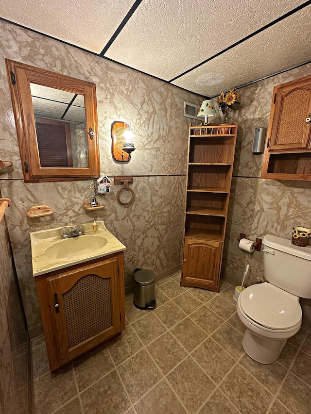 bathroom featuring toilet, tile patterned floors, a textured ceiling, and vanity