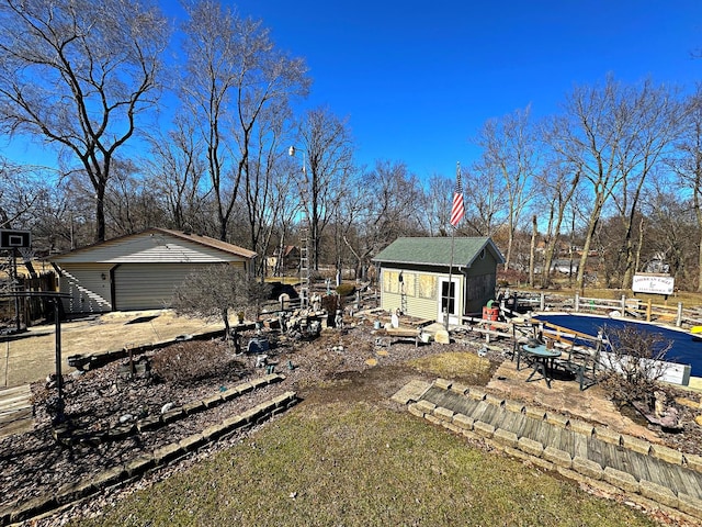 view of yard with an outbuilding, a detached garage, and fence