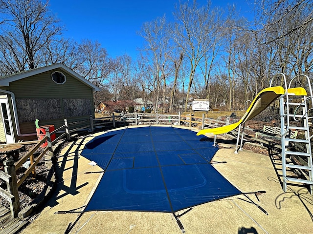 view of swimming pool with a patio area, fence, a fenced in pool, and a water slide