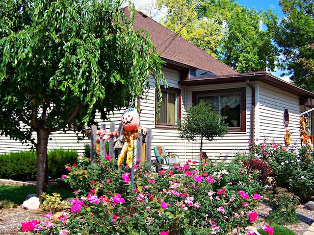 view of side of home with roof with shingles