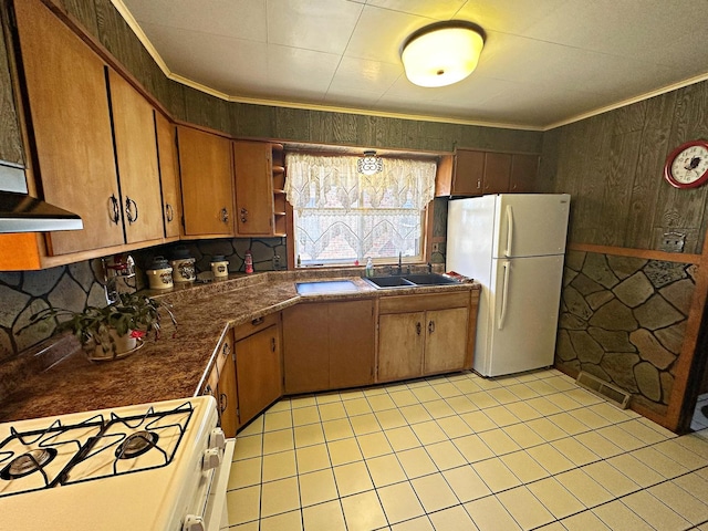 kitchen with white appliances, dark countertops, crown molding, open shelves, and a sink