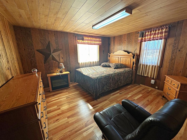 bedroom with light wood-style floors, wood ceiling, and multiple windows