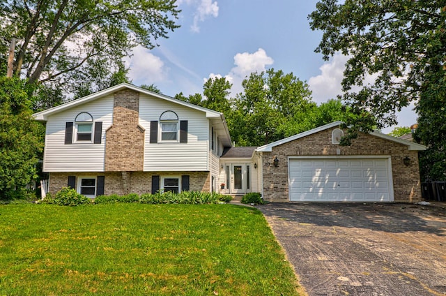 tri-level home featuring a garage, driveway, and brick siding