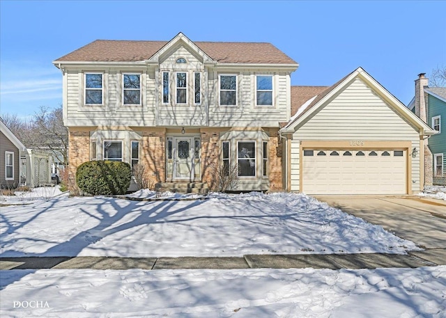 colonial-style house with an attached garage, concrete driveway, and brick siding