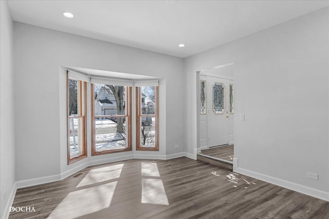 spare room featuring visible vents, baseboards, wood finished floors, and recessed lighting