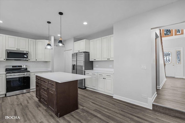 kitchen featuring appliances with stainless steel finishes, light countertops, and dark wood-style floors