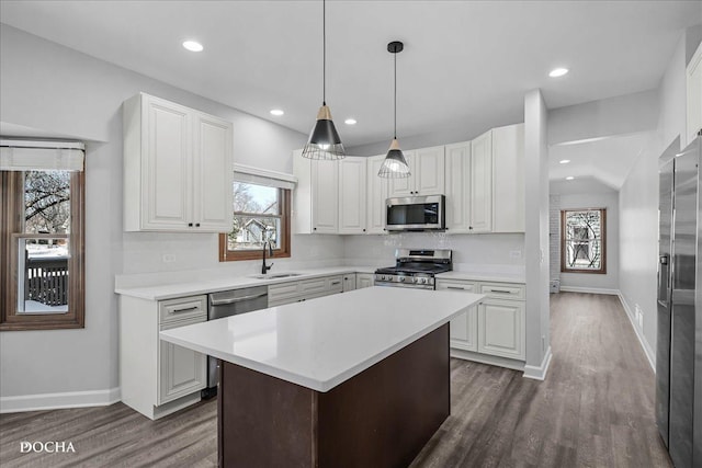 kitchen featuring appliances with stainless steel finishes, light countertops, a sink, and tasteful backsplash