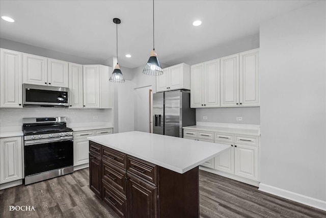 kitchen with dark wood-style flooring, stainless steel appliances, and light countertops