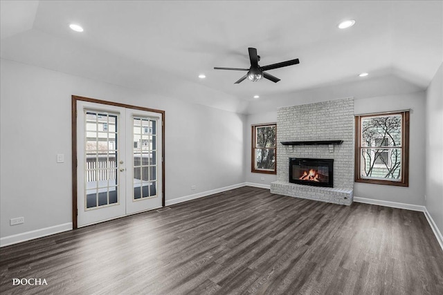 unfurnished living room with vaulted ceiling, dark wood-type flooring, a wealth of natural light, and french doors