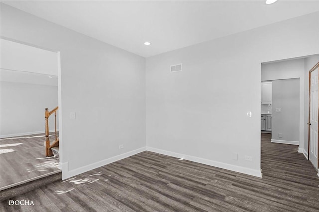 empty room with baseboards, stairway, wood finished floors, and recessed lighting