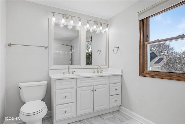 bathroom featuring marble finish floor, a sink, toilet, and baseboards